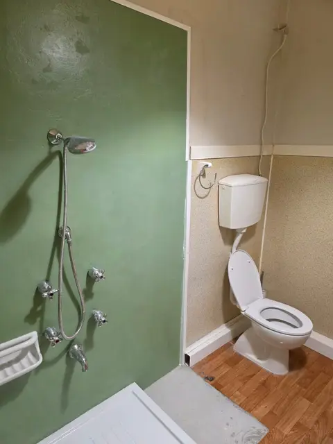 Bagno con parete doccia in resina verde salvia appena completata