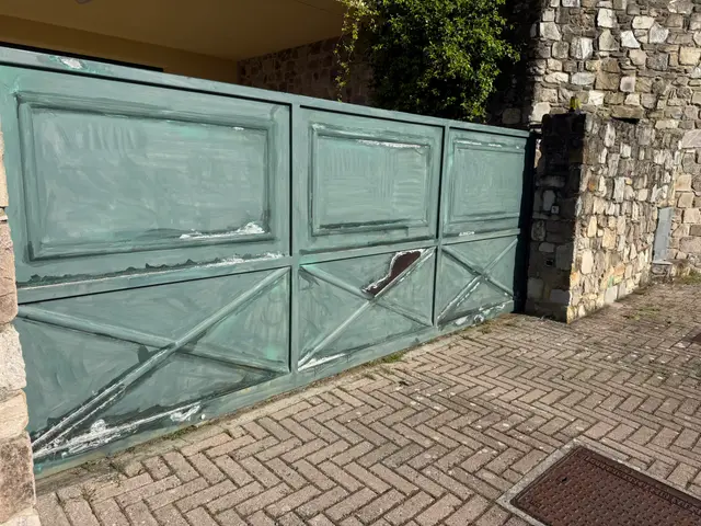 Cancellata in ferro con vernice scrostata prima del trattamento