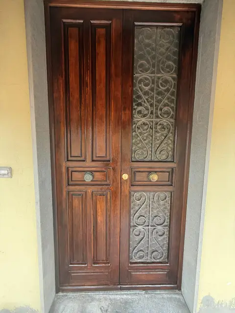 Portone d'epoca in legno con grate in ferro battuto restaurato