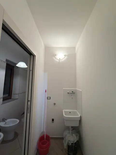 Bagno lavanderia con pareti tinteggiate di bianco