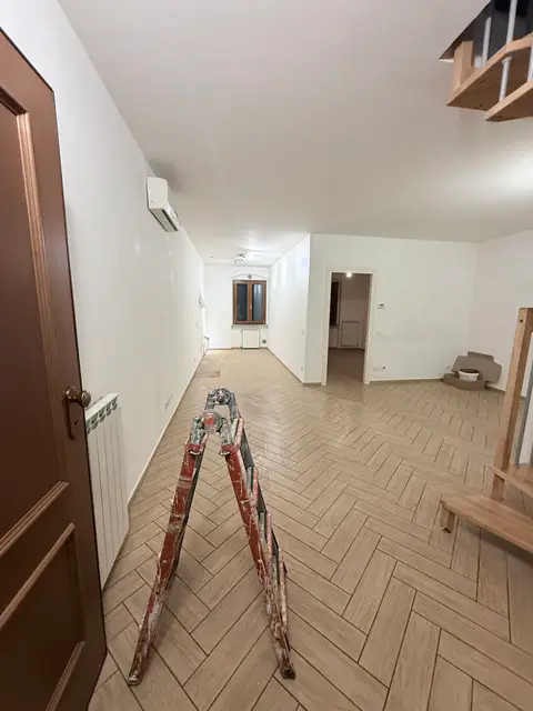 Soggiorno con pareti bianche appena tinteggiate durante il cantiere