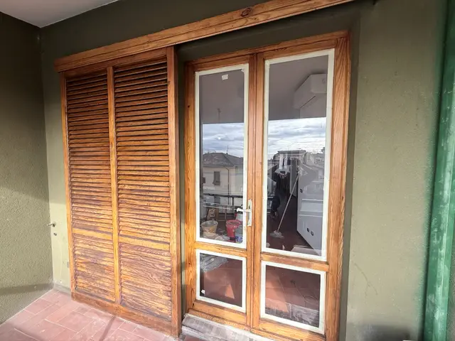 Persiana e portafinestra in legno restaurate su balcone